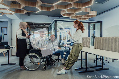 Image of Young group of business people brainstorming together in a startup space, discussing business projects, investments, and solving challenges.