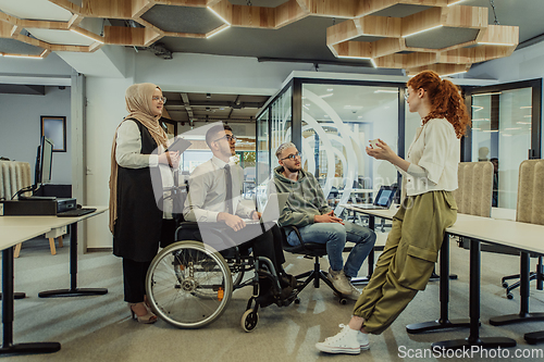 Image of Young group of business people brainstorming together in a startup space, discussing business projects, investments, and solving challenges.