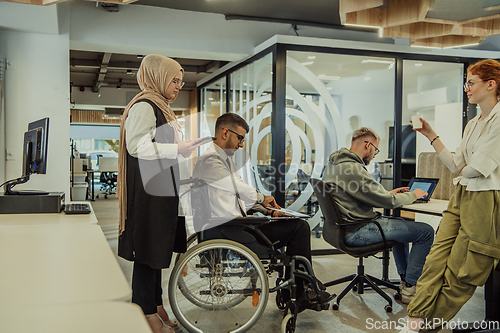 Image of Young group of business people brainstorming together in a startup space, discussing business projects, investments, and solving challenges.