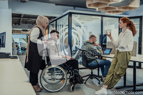 Image of Young group of business people brainstorming together in a startup space, discussing business projects, investments, and solving challenges.