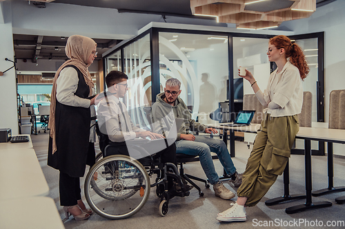 Image of Young group of business people brainstorming together in a startup space, discussing business projects, investments, and solving challenges.