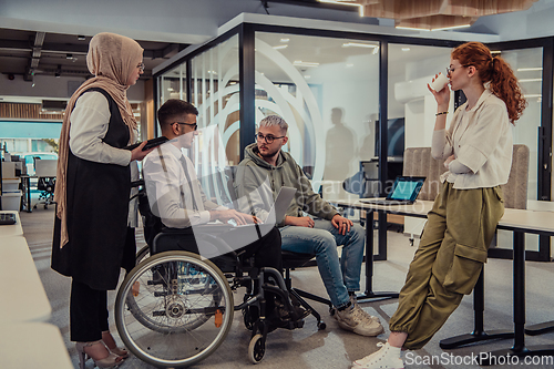 Image of Young group of business people brainstorming together in a startup space, discussing business projects, investments, and solving challenges.