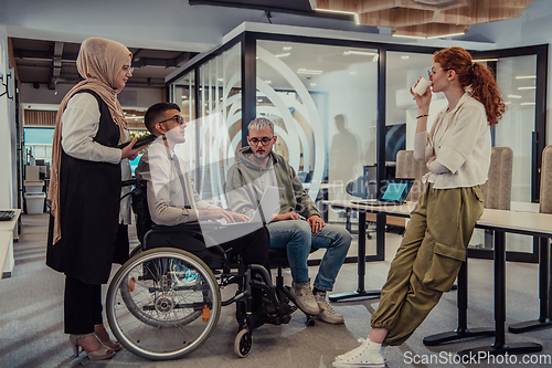 Image of Young group of business people brainstorming together in a startup space, discussing business projects, investments, and solving challenges.