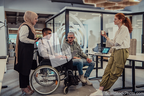 Image of Young group of business people brainstorming together in a startup space, discussing business projects, investments, and solving challenges.