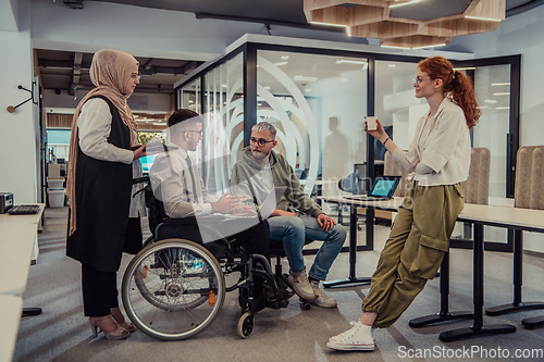 Image of Young group of business people brainstorming together in a startup space, discussing business projects, investments, and solving challenges.