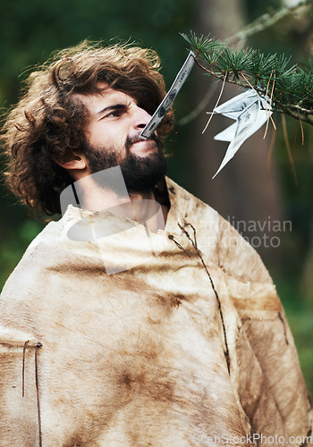 Image of Nature, confused and caveman at a tree for money, finance, or prehistoric. Frustrated, young and a person or man with a note from a leaf for currency, cash or biting financial wealth in the woods