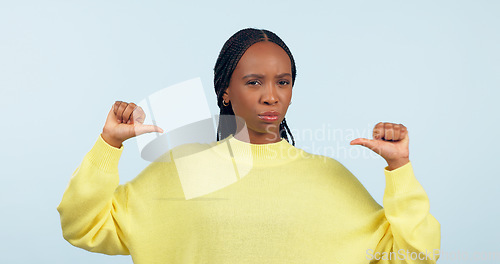 Image of Portrait, attitude and a pointing black woman with confidence in studio on a gray background. Face, frown and expression with a young person looking serious about her fashion or style choice