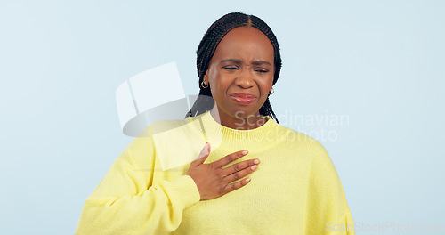 Image of Woman, sick and pain of chest in studio for medical crisis, tuberculosis and cardiovascular healthcare on blue background. African model, heart attack and help for acid reflux, asthma and emergency