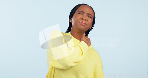 Image of Neck, pain and injury of woman in studio with stress, risk of arthritis and tired joints on blue background. African model massage spine muscle for first aid, health emergency and crisis of fatigue