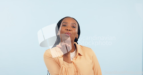 Image of Love, black woman and blowing a kiss in portrait, studio and blue background with flirting or romance. Lips, pouting and gen z person or emoji with confidence, happiness and mock up space with care