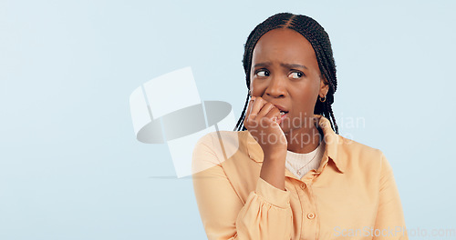 Image of Woman, anxiety and biting nails in studio for stress, bad habit and thinking of horror on blue background. Nervous african model chewing fingers for terror, worry and scared of fear with mockup space