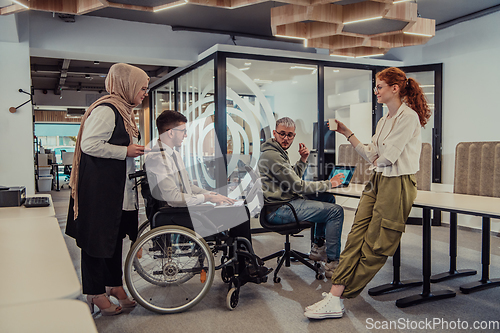 Image of Young group of business people brainstorming together in a startup space, discussing business projects, investments, and solving challenges.