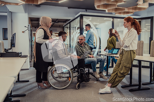 Image of Young group of business people brainstorming together in a startup space, discussing business projects, investments, and solving challenges.