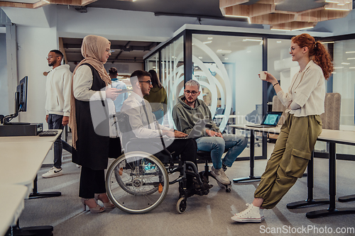 Image of Young group of business people brainstorming together in a startup space, discussing business projects, investments, and solving challenges.