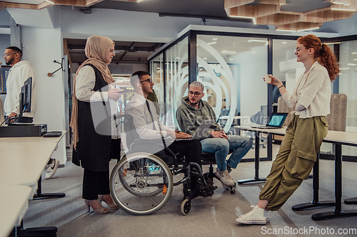 Image of Young group of business people brainstorming together in a startup space, discussing business projects, investments, and solving challenges.