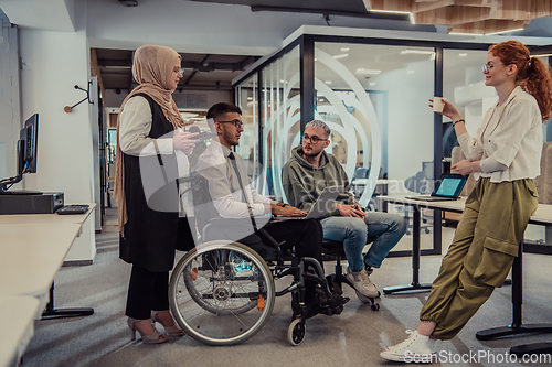 Image of Young group of business people brainstorming together in a startup space, discussing business projects, investments, and solving challenges.