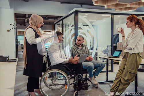 Image of Young group of business people brainstorming together in a startup space, discussing business projects, investments, and solving challenges.