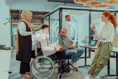 Image of Young group of business people brainstorming together in a startup space, discussing business projects, investments, and solving challenges.