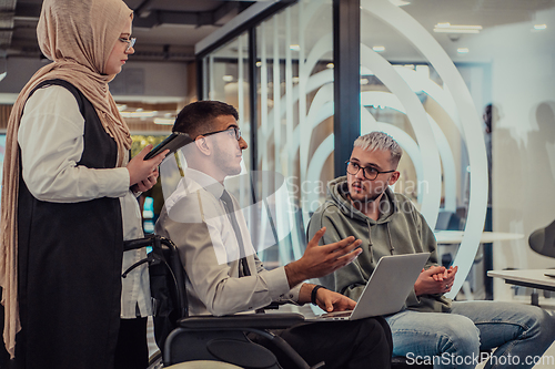 Image of Young group of business people brainstorming together in a startup space, discussing business projects, investments, and solving challenges.