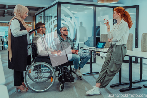 Image of Young group of business people brainstorming together in a startup space, discussing business projects, investments, and solving challenges.