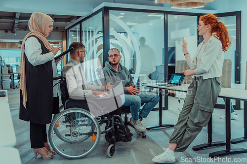 Image of Young group of business people brainstorming together in a startup space, discussing business projects, investments, and solving challenges.