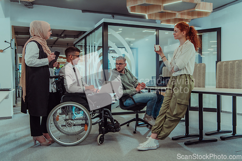 Image of Young group of business people brainstorming together in a startup space, discussing business projects, investments, and solving challenges.