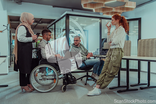 Image of Young group of business people brainstorming together in a startup space, discussing business projects, investments, and solving challenges.