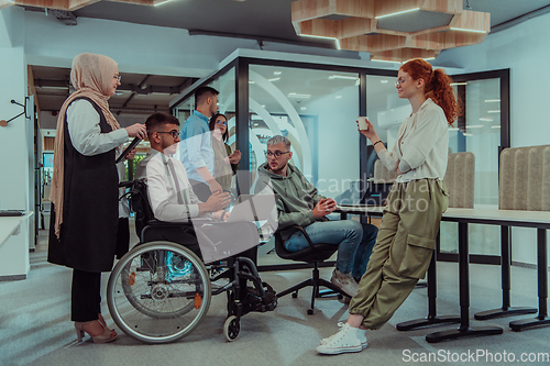 Image of Young group of business people brainstorming together in a startup space, discussing business projects, investments, and solving challenges.