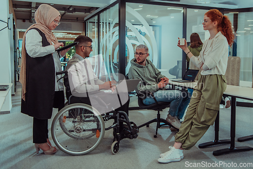 Image of Young group of business people brainstorming together in a startup space, discussing business projects, investments, and solving challenges.