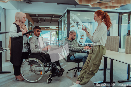 Image of Young group of business people brainstorming together in a startup space, discussing business projects, investments, and solving challenges.