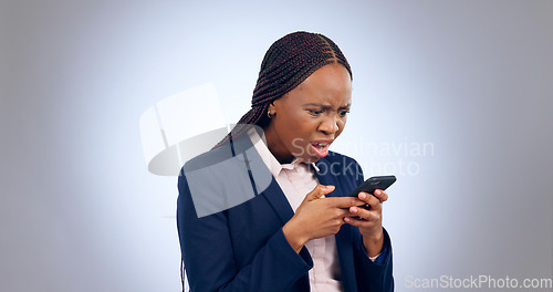 Image of Stress, phone and confused black woman frustrated by text in studio with fake news, review or feedback on grey background. Surprise, anxiety and African entrepreneur shocked by social media hacker