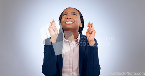 Image of Business woman, fingers crossed and hope in studio for luck, thinking of wish or waiting for announcement on grey background. Nervous african worker, hand emoji or anxiety while praying for good news