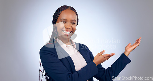 Image of Portrait, business woman and presentation of space, mockup or announcement of promotion in studio on grey background. Happy african worker advertising launch of deal, feedback or information about us