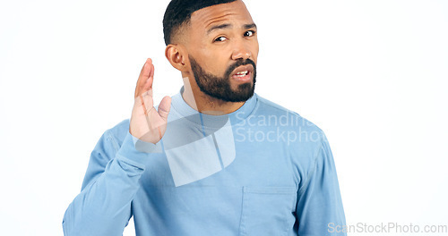 Image of Portrait, secret or gossip with a man listening in studio isolated on a white background for communication. Face, hand and hearing with a young person looking confused about news, audio or sound
