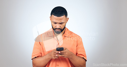 Image of Confused, text and man in studio reading fake news, email or error notification on grey background. Doubt, smartphone and male model with with app password glitch, 404 or phishing, scam or review