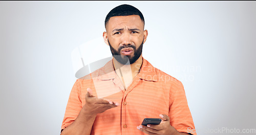 Image of Portrait of man in studio with phone, frustrated and confused with connection problem, 404 or glitch. Communication, anger and person with smartphone with scam, phishing or fraud on white background.