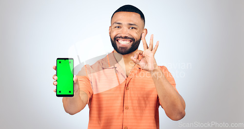 Image of Man, portrait and ok for phone with green screen, space or agreement in studio on white background. Happy model, smartphone or yes emoji for certified newsletter, promotion or advertising information