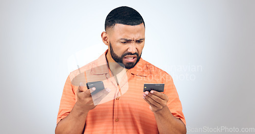 Image of Man in studio with phone, credit card and frustrated with connection problem, debt or glitch. Fintech, anger or confused person with smartphone for banking, online shopping or 404 on white background