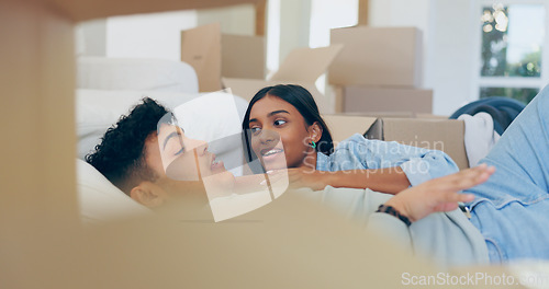 Image of Couple, talk and relax after move to new home by lying on sofa in living room with boxes. Married people, bonding and ready for future with property investment, mortgage loan or sale in real estate