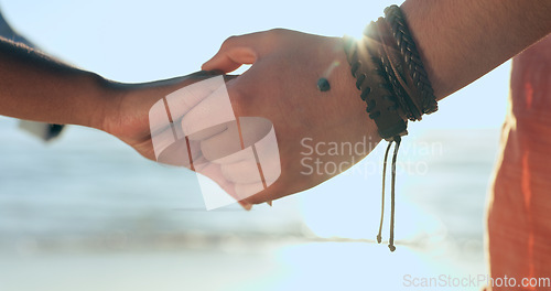 Image of Love, zoom and couple holding hands at a beach with respect, gratitude and trust in nature together. Commitment, closeup and people together at sea with support, kindness and summer travel freedom