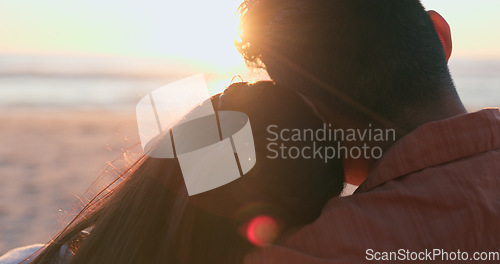 Image of Sunset, beach and back of couple hug in nature for travel, bond or weekend freedom with lens flare. Sunrise, love and rear view or people embrace at sea for adventure, journey or romance at the ocean