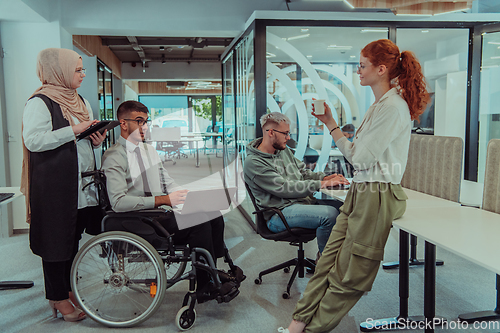 Image of Young group of business people brainstorming together in a startup space, discussing business projects, investments, and solving challenges.