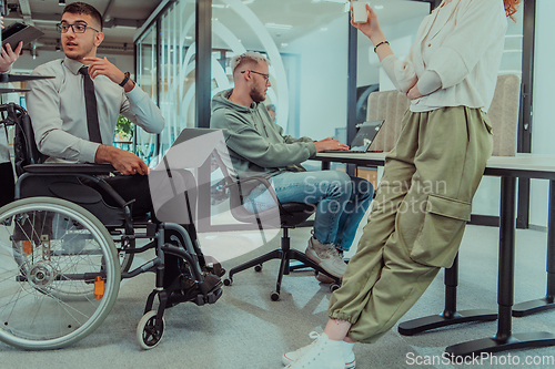 Image of Young group of business people brainstorming together in a startup space, discussing business projects, investments, and solving challenges.