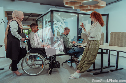 Image of Young group of business people brainstorming together in a startup space, discussing business projects, investments, and solving challenges.