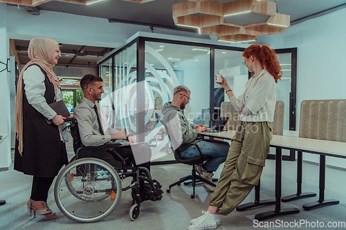 Image of Young group of business people brainstorming together in a startup space, discussing business projects, investments, and solving challenges.