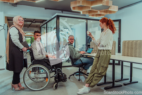 Image of Young group of business people brainstorming together in a startup space, discussing business projects, investments, and solving challenges.