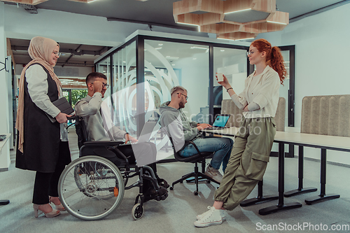 Image of Young group of business people brainstorming together in a startup space, discussing business projects, investments, and solving challenges.