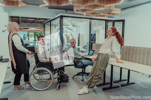 Image of Young group of business people brainstorming together in a startup space, discussing business projects, investments, and solving challenges.