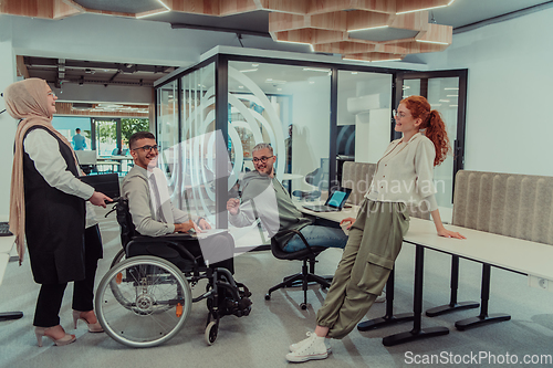 Image of Young group of business people brainstorming together in a startup space, discussing business projects, investments, and solving challenges.