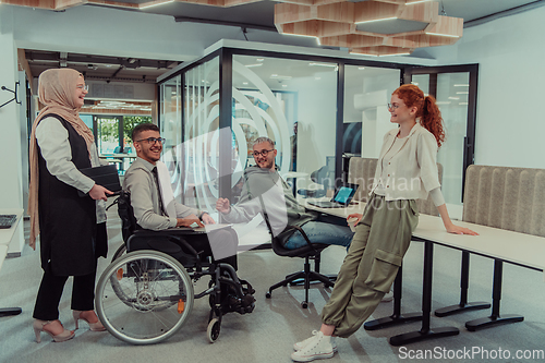 Image of Young group of business people brainstorming together in a startup space, discussing business projects, investments, and solving challenges.